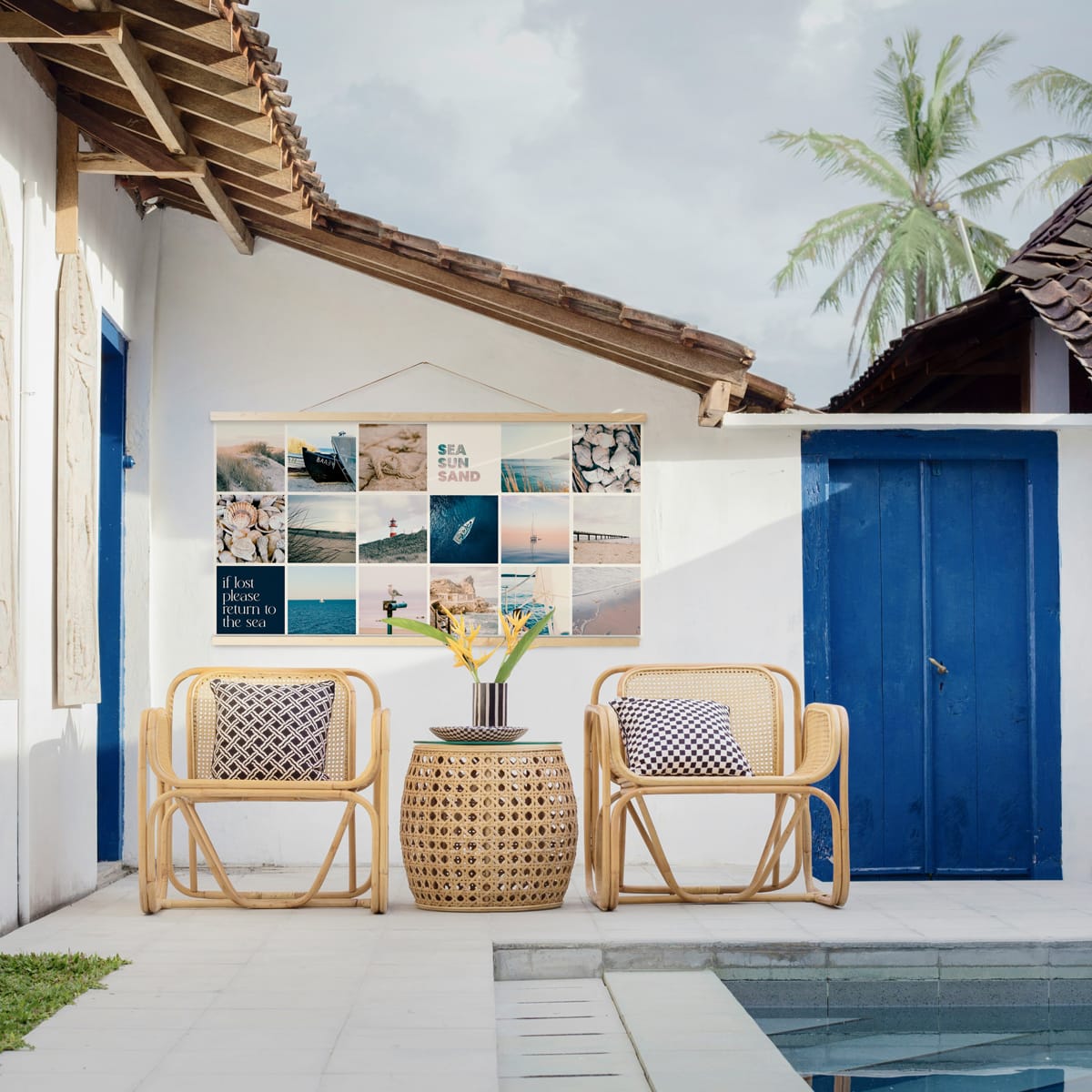 Instawall Tuinposter Wide 2:1 fotocollage als tuinwanddecoratie aan witte muur met wickerstoelen en blauwe deuren